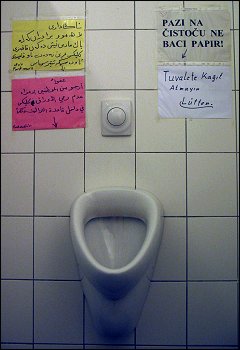 multilingual beschriftetes Urinal im Gebrauchtwarenkaufhaus 'Pack mers' zu Forchheim (Oberfr)