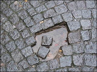 Lücke im Pflasterbelag der Zugangsrampe zur Bahnsteigunterführung