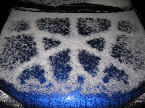 Der erste Schnee des Jahres auf den Motorhauben abgestellter Autos