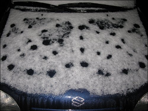 Der erste Schnee des Jahres auf den Motorhauben abgestellter Autos