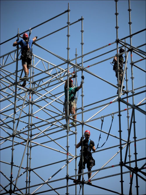 Schwindelfreie Arbeiter beim Errichten eines Baugerüstes im Castello di Udine