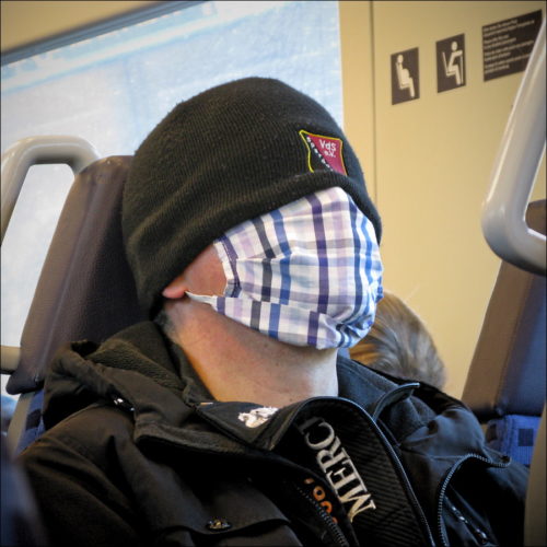 Masken-Mann im Morgenzug